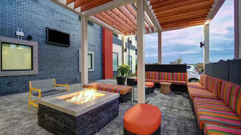 Covered outdoor patio with fire table. Home2 Suites by Hilton, Blacksburg, VA