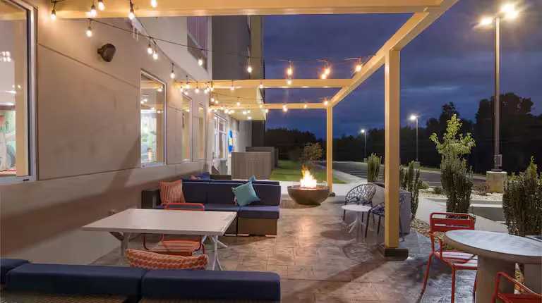 Covered terrace with fire pit at twilight. Tru by Hilton, Lexington, VA